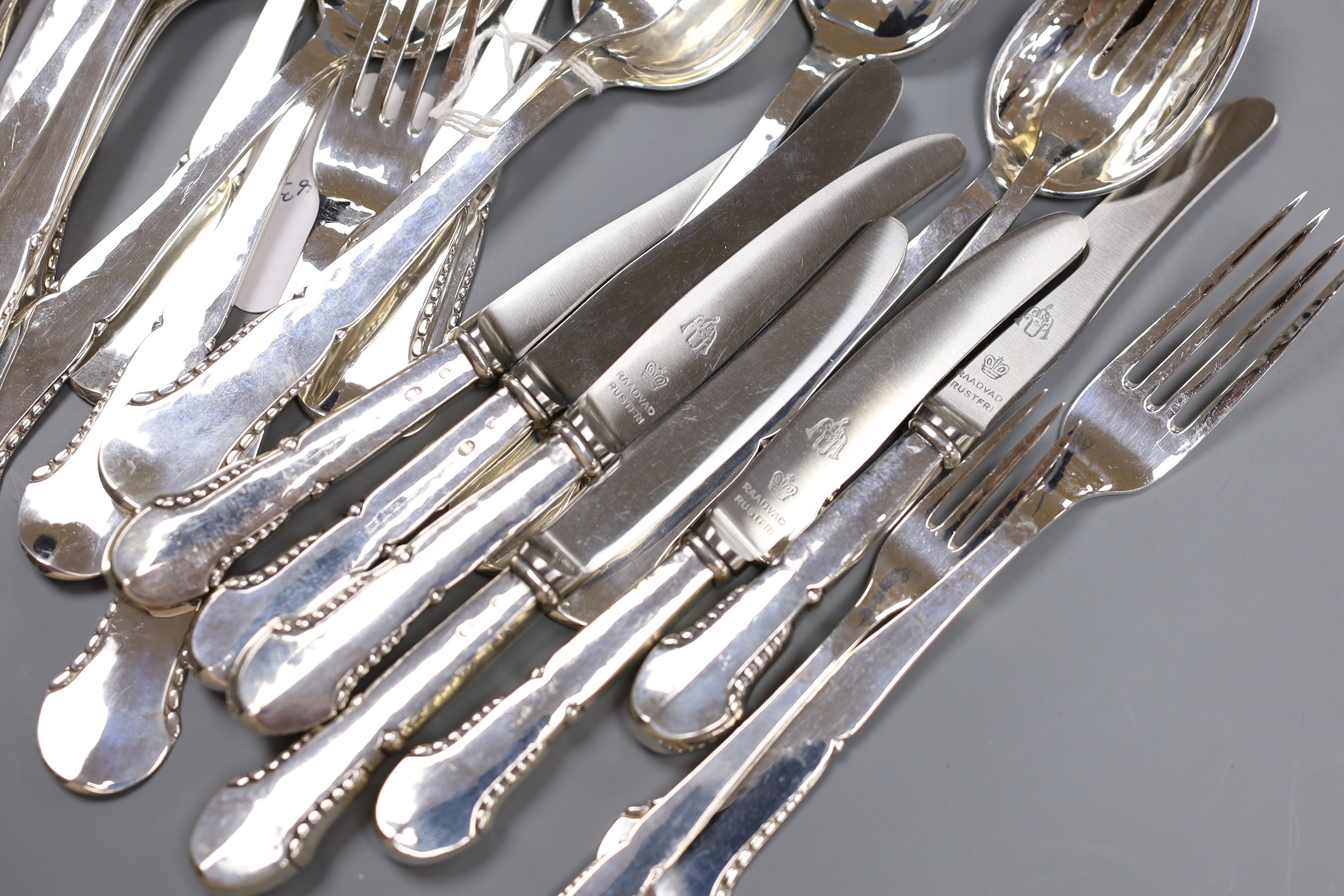 A Danish twenty eight piece white metal canteen of silver flatware and cutlery, comprising ten dessert spoons, six table forks, six three prong forks and six white metal handled steel knives